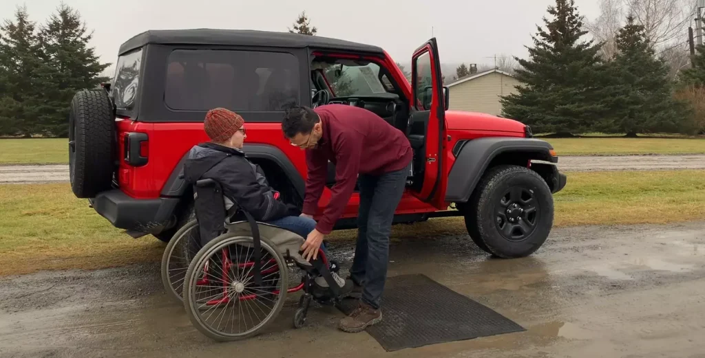 James Ndungu uses Glide 'n Go to lift a person into the driver's seat of a Current Jeep Wrangler with an extra 6" of height for off-roading purposes, James learns that the driver needs to be able to lift themselves an additional 6" from the wheelchair to the Glide 'n Go when using a lifted Jeep in order to go off-roading in the Jeep