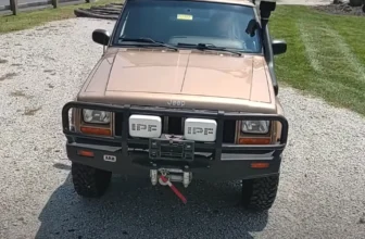 Synthetic Jeep Cherokee bumper winch installed on the front bumper of a Jeep Cherokee, featuring a durable synthetic rope and rugged construction for off-road use.