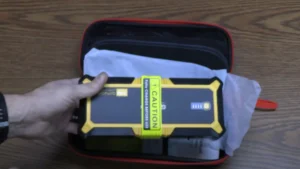 Gooloo GP4000 Portable Jump Starter being unboxed, showing the device and accessories inside the box.